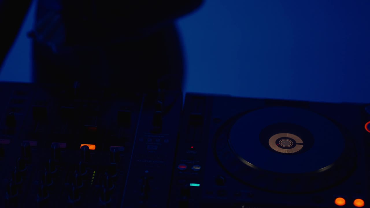 性感女人DJ和现代DJ控制器在夜总会，年轻女士DJ混音轨道，俱乐部在晚上视频下载