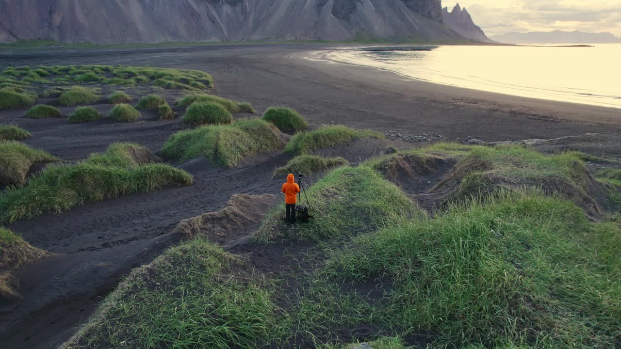 黑沙滩上的Vestrahorn山的景观和站在冰岛Stokksnes半岛的男性游客视频下载
