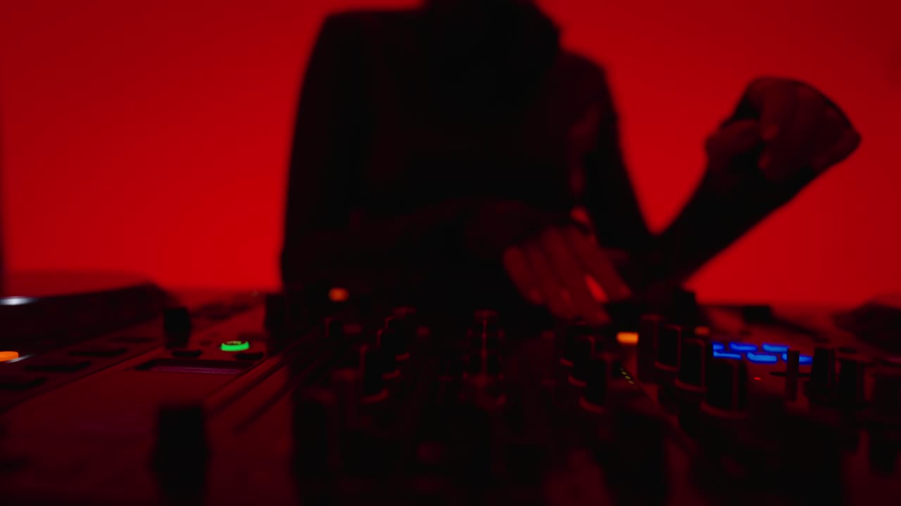女DJ混音轨道的DJ混音器，女音乐家在DJ控制器上播放旋转手柄视频下载