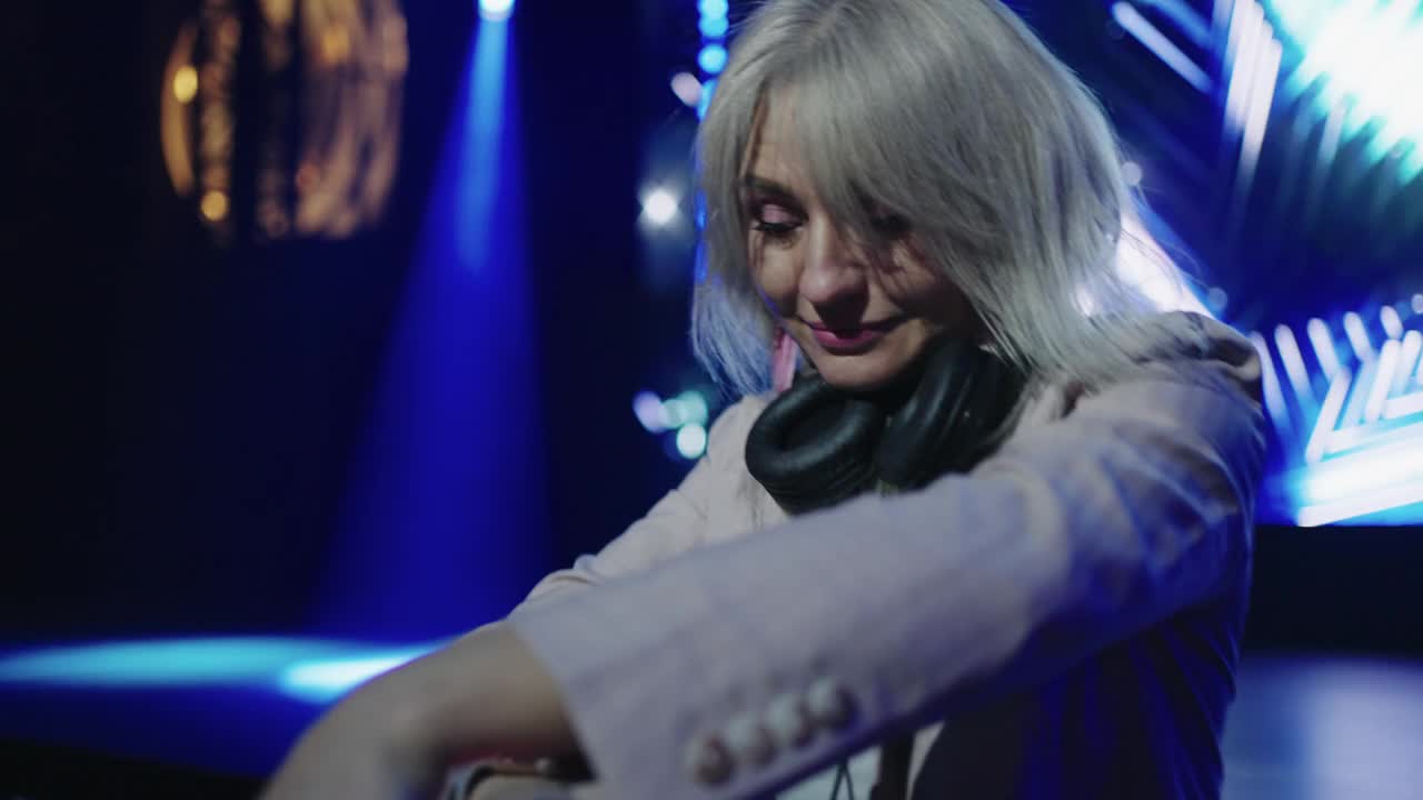 中年女性DJ在夜总会、舞会上演奏现代电子音乐的肖像视频下载