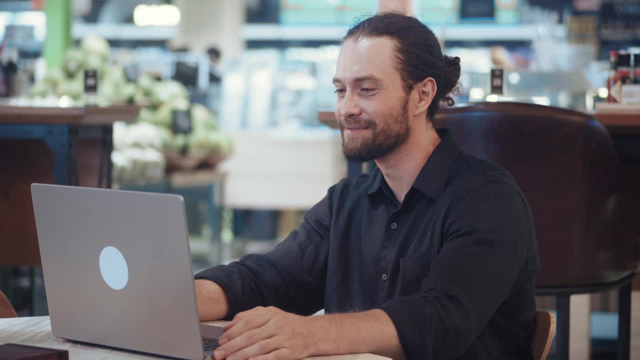 一个坐在笔记本电脑前的商人对一个成功的创业公司说“是”。一个兴奋的人看着笔记本电脑的屏幕，为胜利或成功的创业而欢欣鼓舞。视频下载