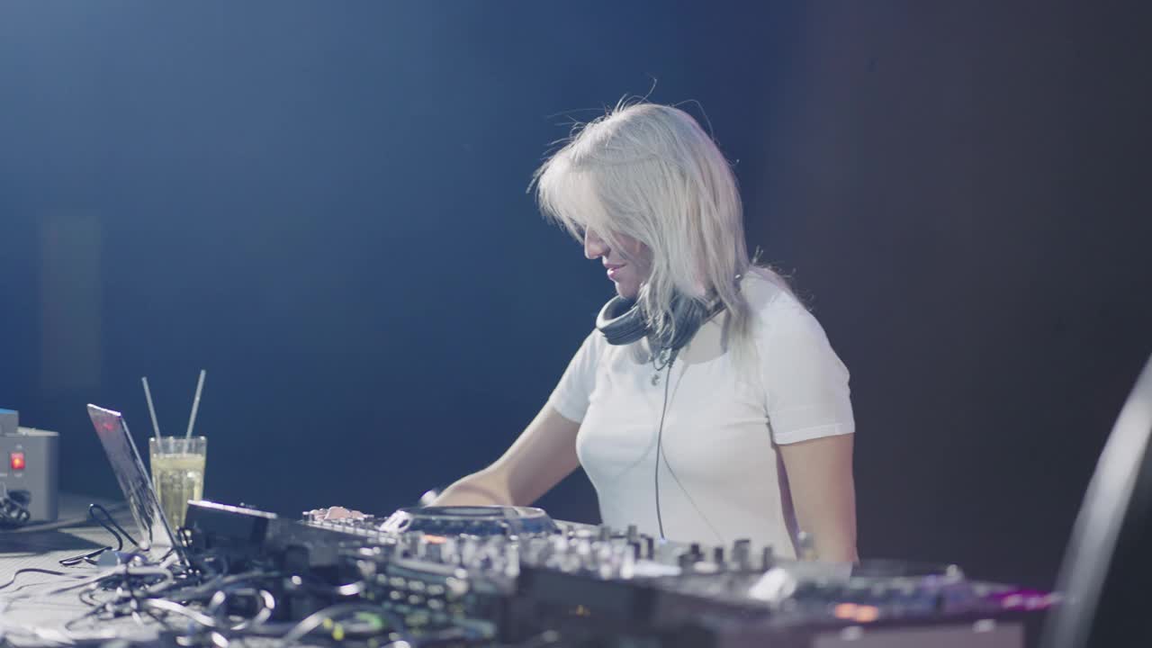 女DJ背后的现代DJ混音器，肖像在夜总会，女性播放音乐和混音轨道视频下载