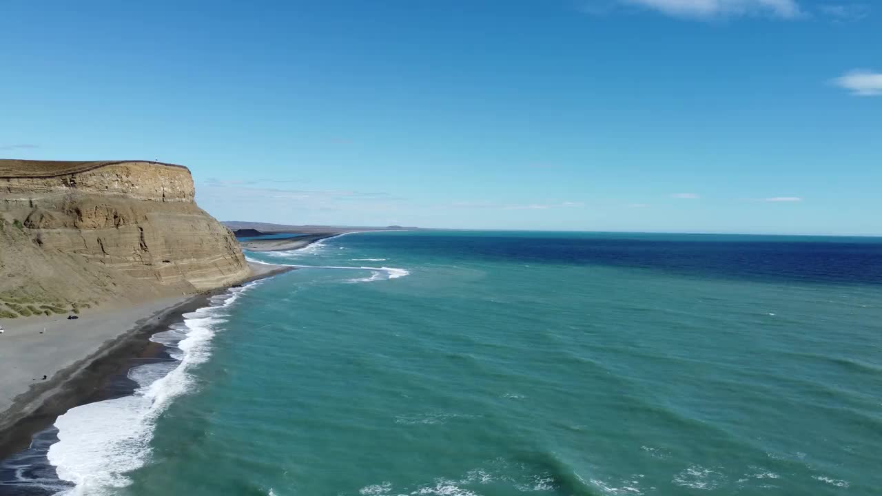相机从高处俯瞰黑色沙滩和深绿色大海的长滩视频下载