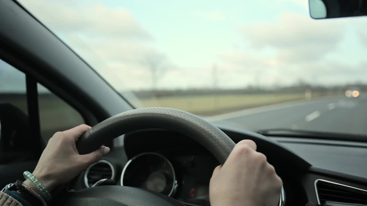 女性手握方向盘，女孩开车上路视频下载