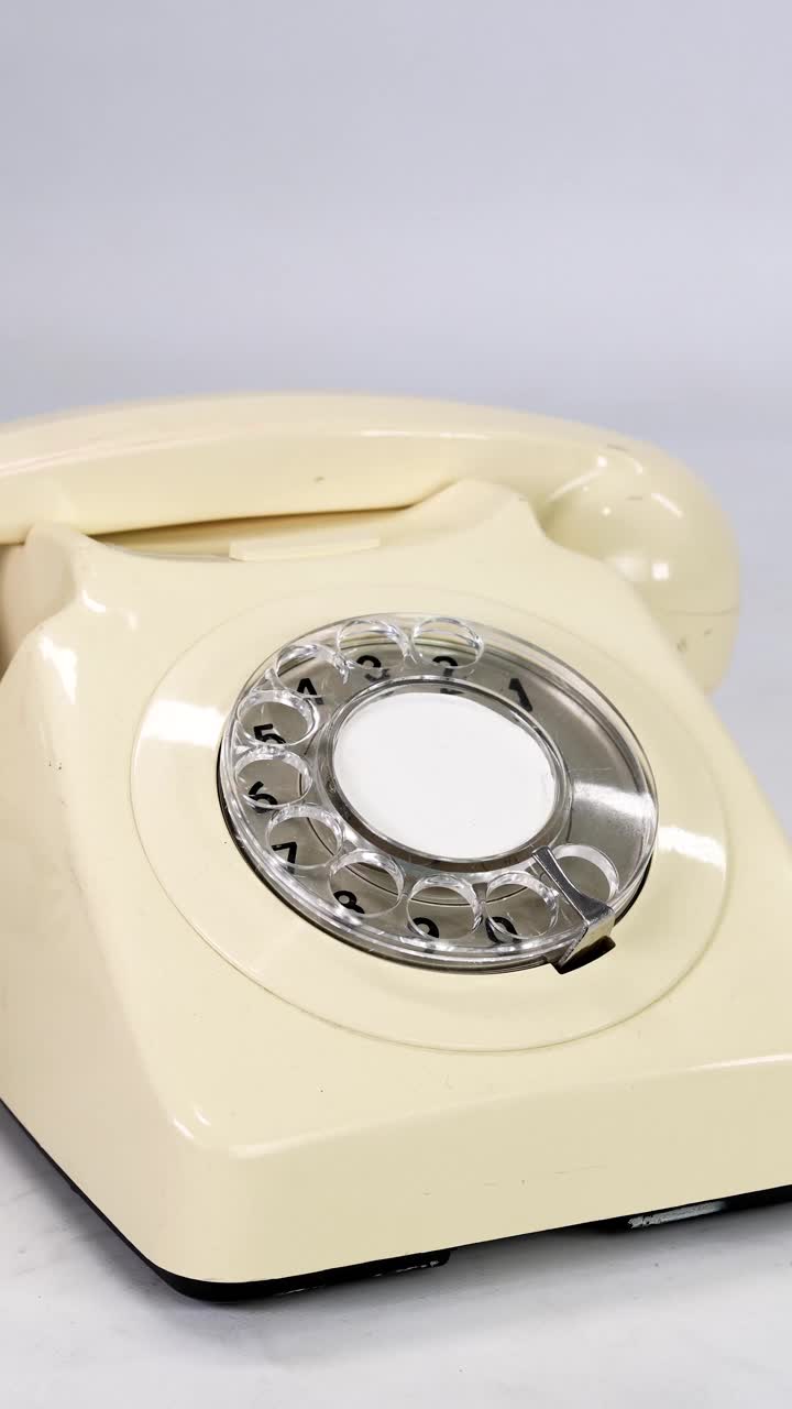 一部老式复古风格的英国电话的肖像镜头，一个男人拿起话筒，又放下话筒，背景是白色的视频下载