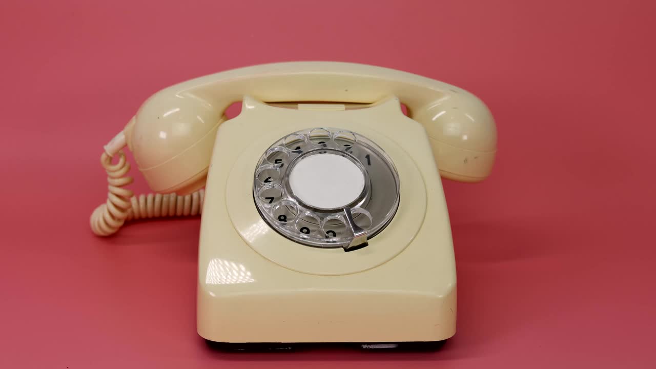 一个古老的复古风格的英国电话，在粉红色的背景上，一个男人的手拿起听筒，然后放下听筒视频下载