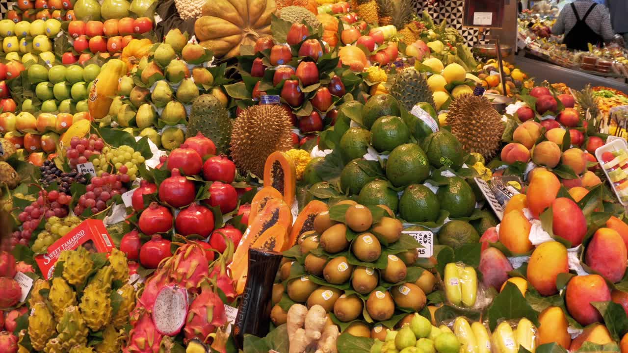 在La Boqueria食品市场展示新鲜的热带水果和蔬菜。西班牙巴塞罗那视频下载