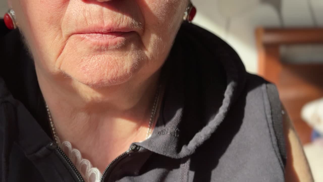 一位老年妇女的特写镜头，她在吃完东西后把药片放进嘴里视频下载
