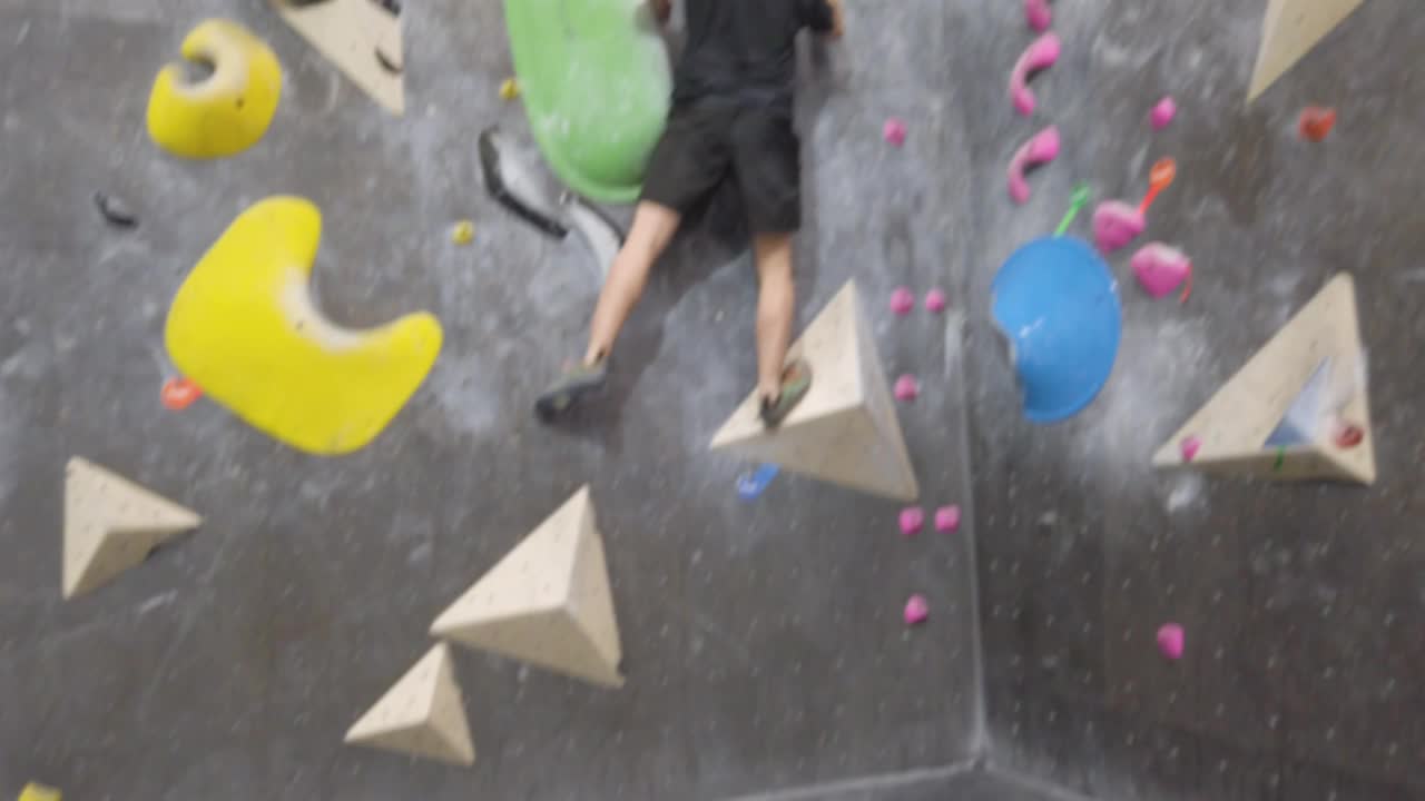 亚洲攀岩者在健身房攀爬室外抱石墙。有趣的室内运动活动。视频素材