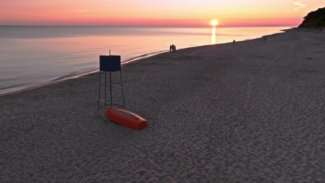 海滩上的日出，有救生员小屋和海上的船视频下载