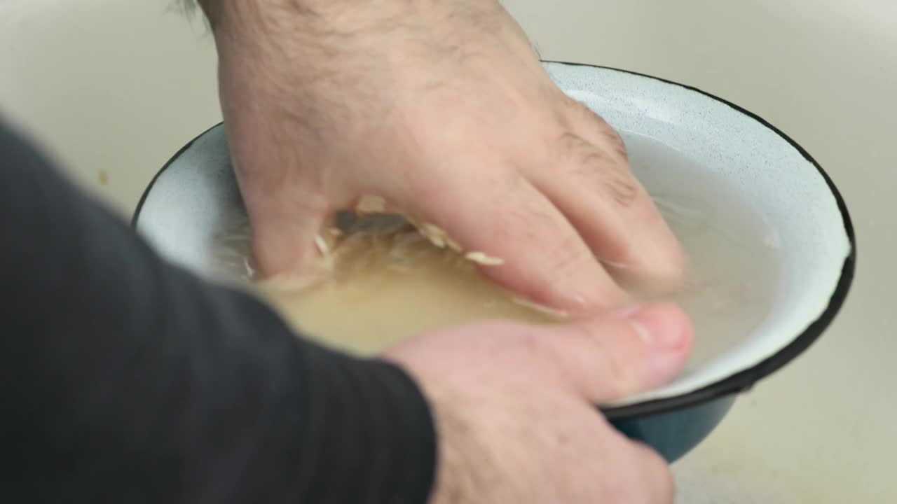 男子在厨房水槽上洗碗饭，特写镜头视频下载