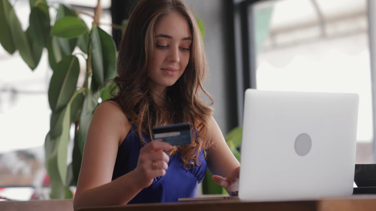 在线购物。女人用笔记本电脑和信用卡。视频下载
