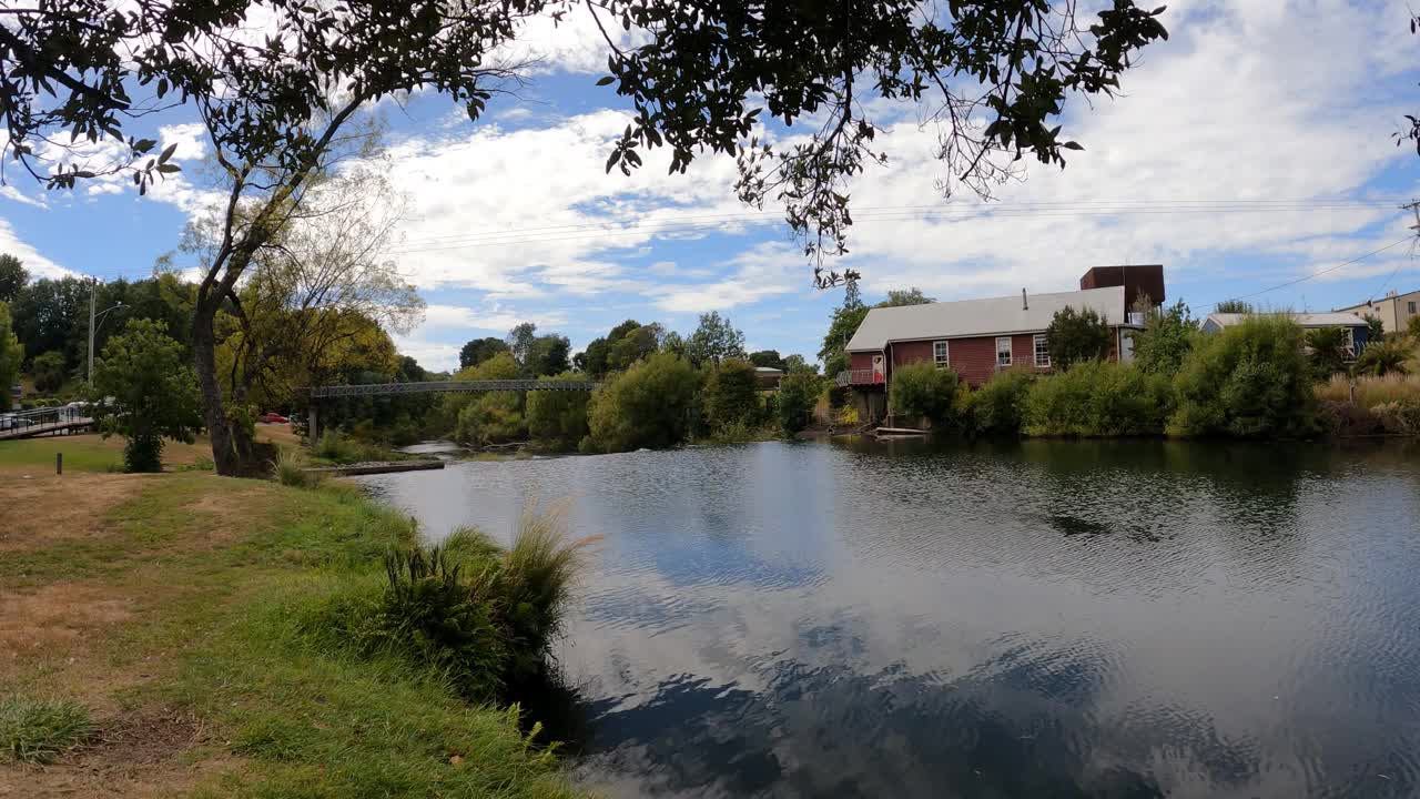 在阳光明媚的日子里，德洛雷恩镇蜿蜒河的延时拍摄。桥和房子视频下载