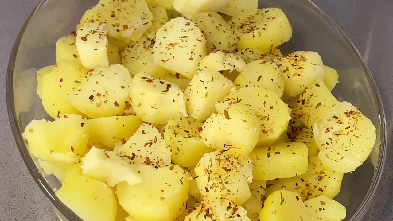 用辣椒粉给煮熟的土豆片调味视频下载