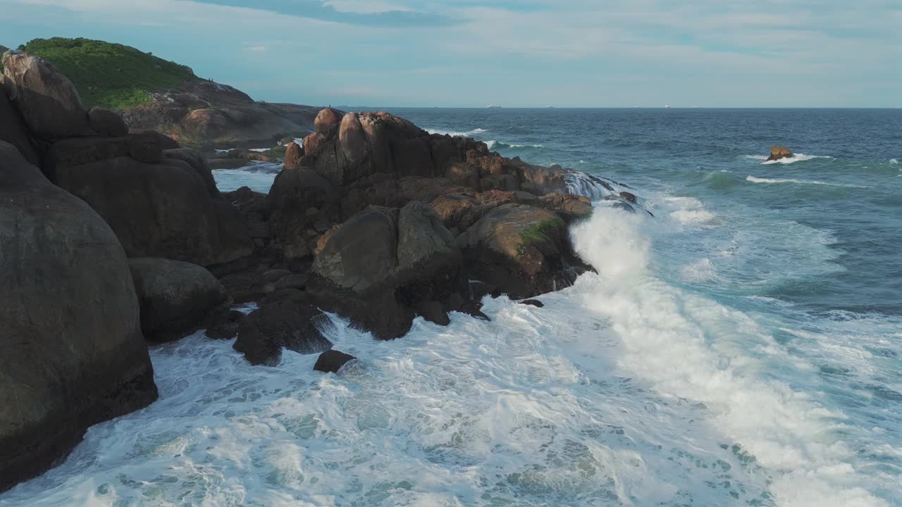 海浪冲击岩石海岸的迷人景象，大自然的力量和美丽的迷人展示。视频下载