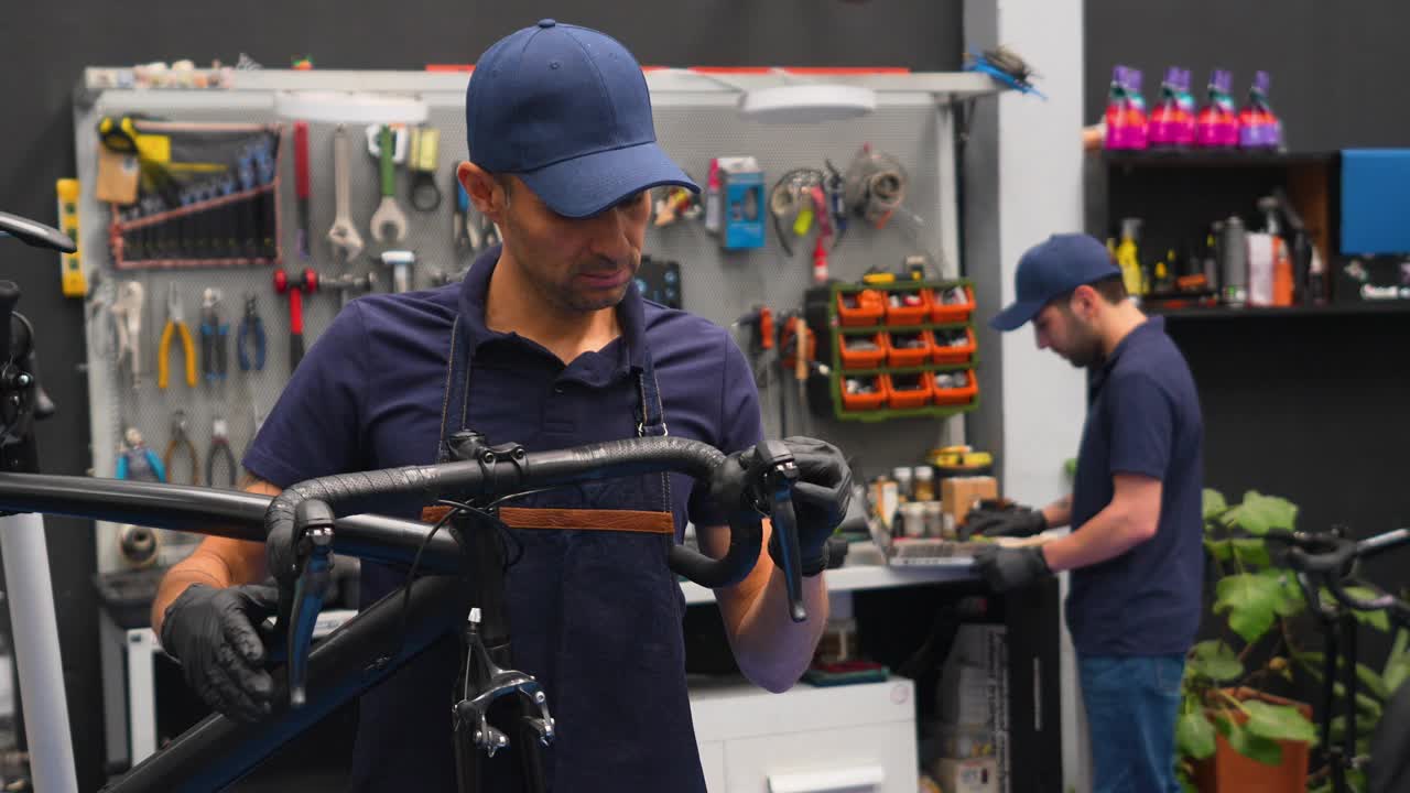 一个拉丁美洲的机械师在修理店修理自行车的刹车把手视频下载