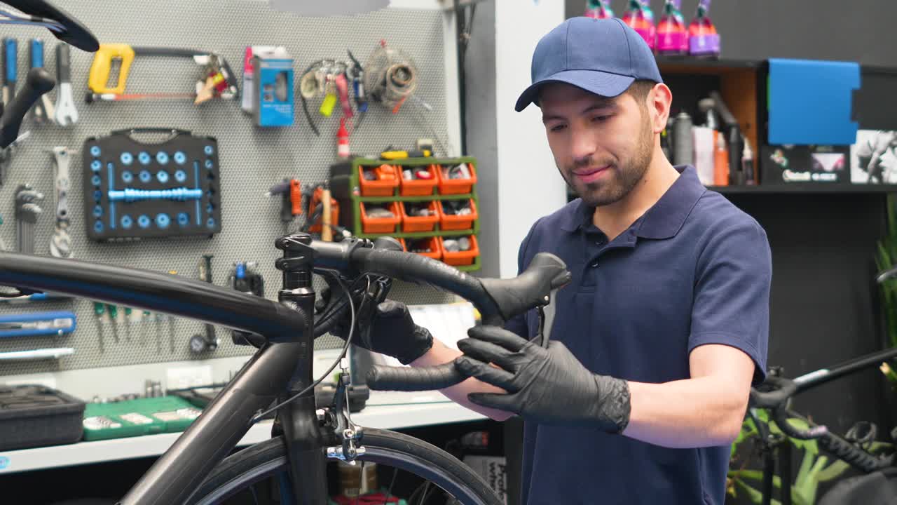 友好的自行车修理工在他的车间看着相机微笑视频下载