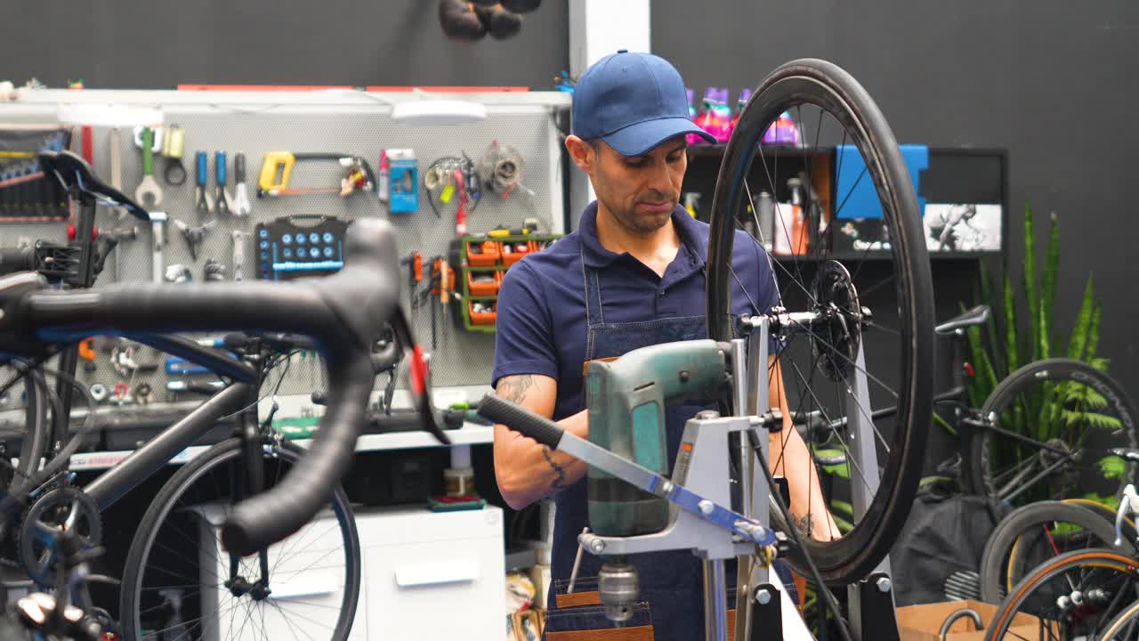 男机械师在店里的设备上平衡自行车轮子视频下载