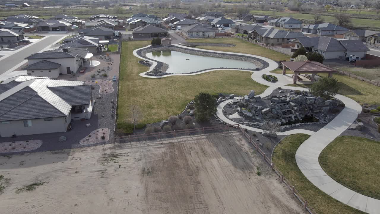 倾斜无人机观看社区公园与草坪和池塘在一个行政住宅分区视频下载