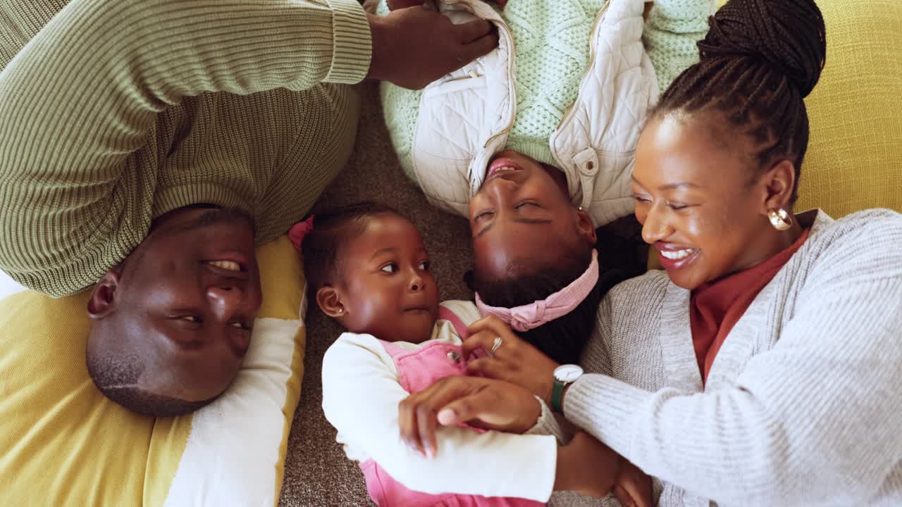 楼上和黑人家庭在客厅或休息室快乐地玩耍，爱和亲情在一起。有趣的是，妈妈和非洲爸爸享受与孩子们在一起的美好时光，享受照顾、放松和快乐视频下载