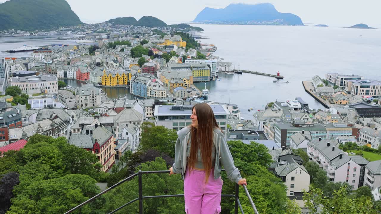 背着背包的快乐女人从上面欣赏挪威奥勒松市视频下载