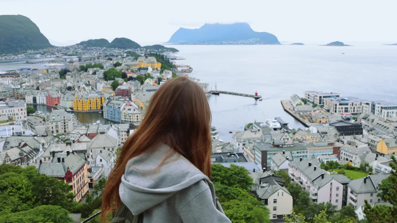 背着背包的快乐女人从上面欣赏挪威奥勒松市视频下载
