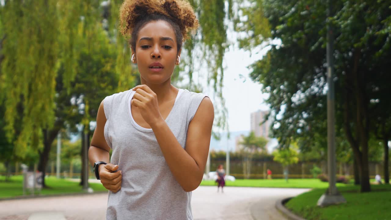 在公园跑步时检查了她的健身追踪器后，疲惫的女人在庆祝视频下载