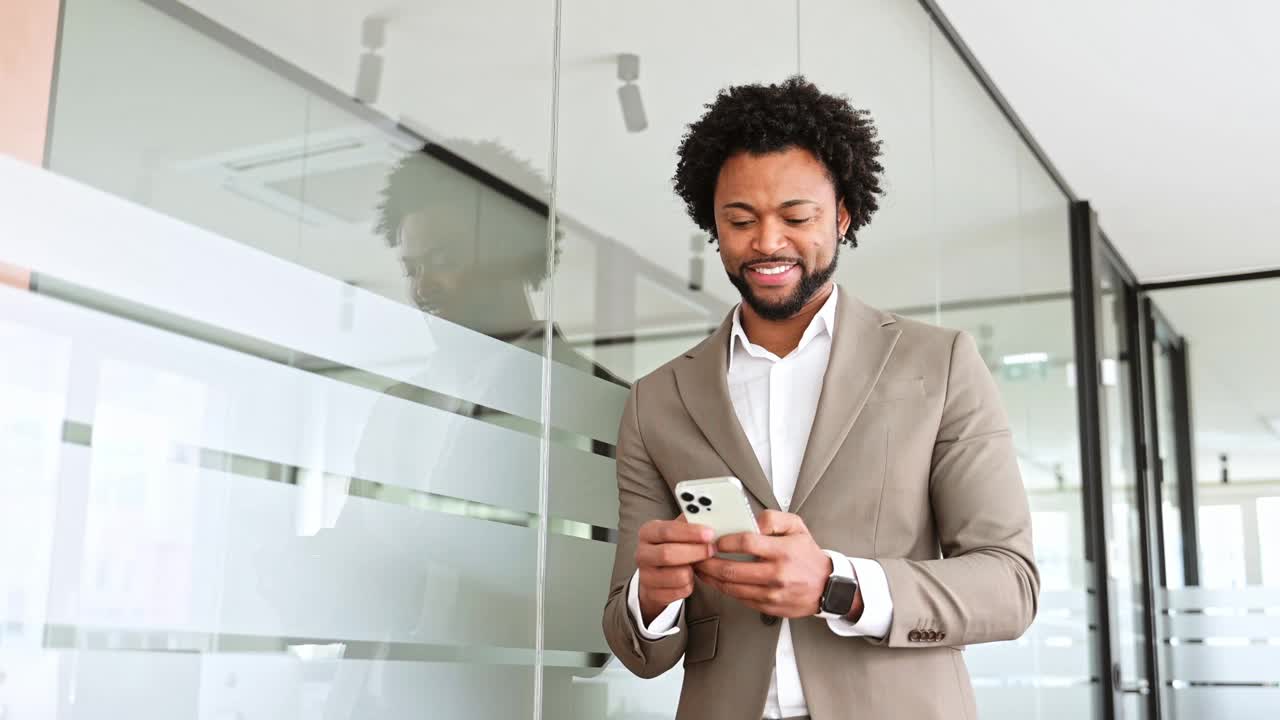 一位精通商业的非裔美国人正在玩他的智能手机视频下载