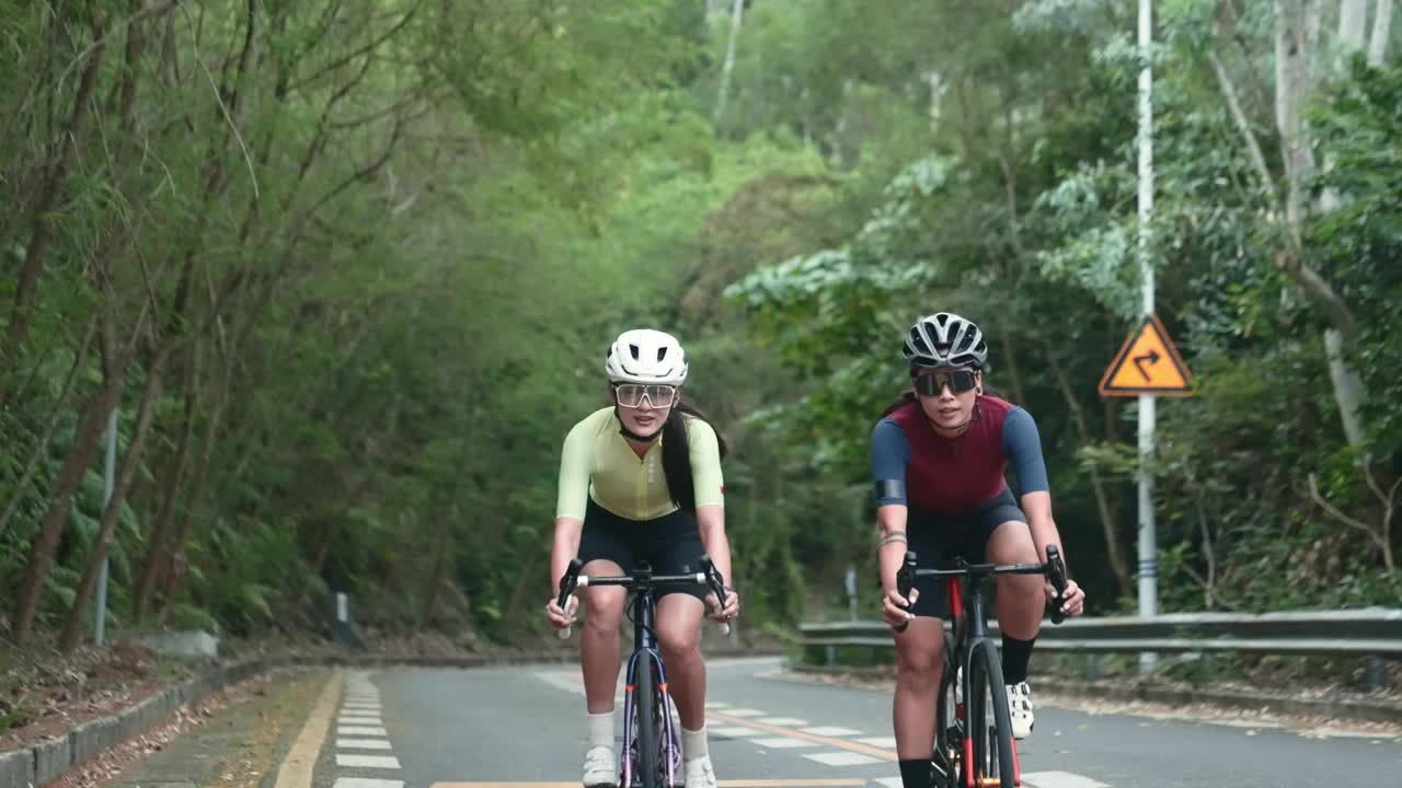 年轻的亚洲自行车手在乡村道路上骑自行车视频下载