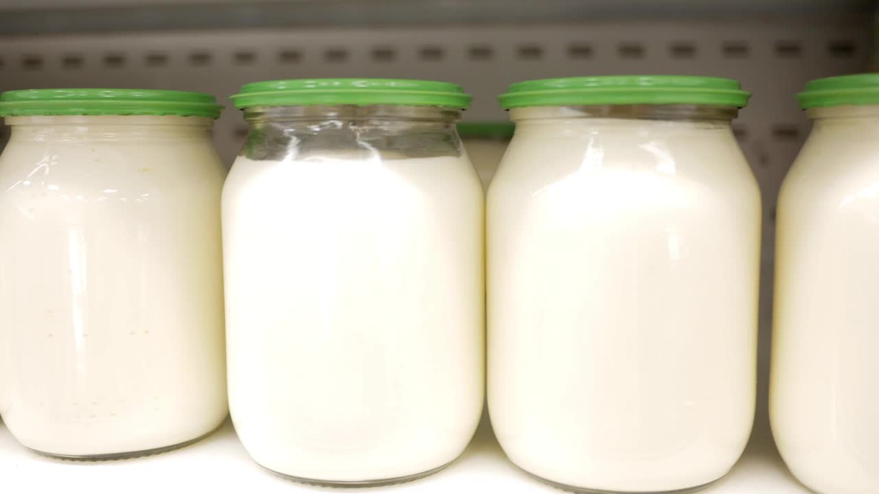 商店货架上展示的白酱或酸奶油。玻璃罐里的蛋黄酱。视频下载