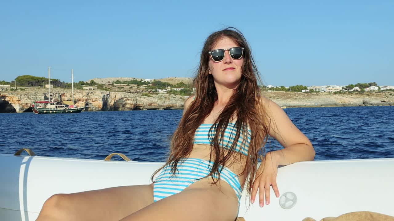 女子在游艇上放松，欣赏意大利南海岸田园诗般的风景视频下载