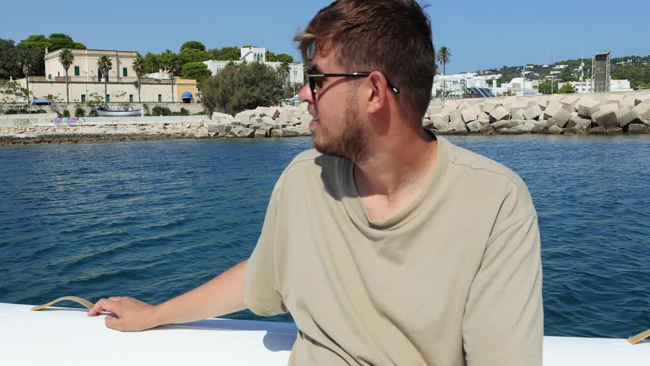 男子在游艇上放松，欣赏意大利南海岸田园诗般的风景视频下载