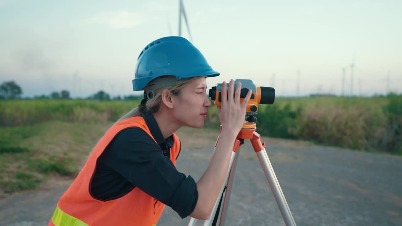 亚洲女工程师在风电场现场用经纬仪进行精密测量视频下载