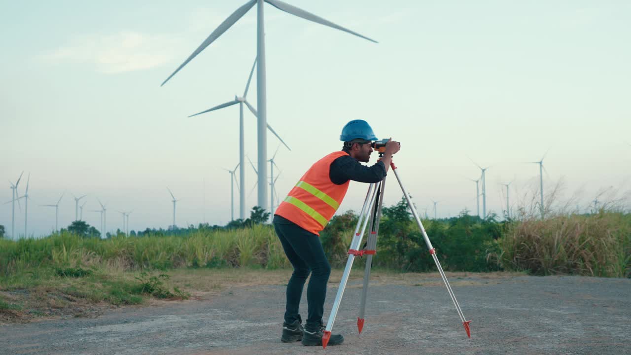 日落时分，亚洲测量工程师在风电场现场使用经纬仪视频下载