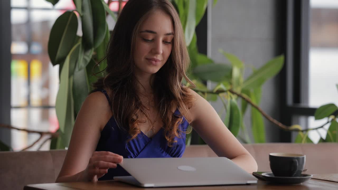 女自由职业者在咖啡馆用笔记本电脑工作视频下载