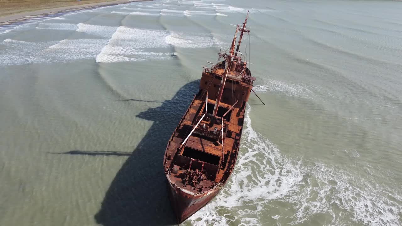 镜头向下看，在巴塔哥尼亚海岸的浅水区，一艘生锈的沉船被包围视频下载