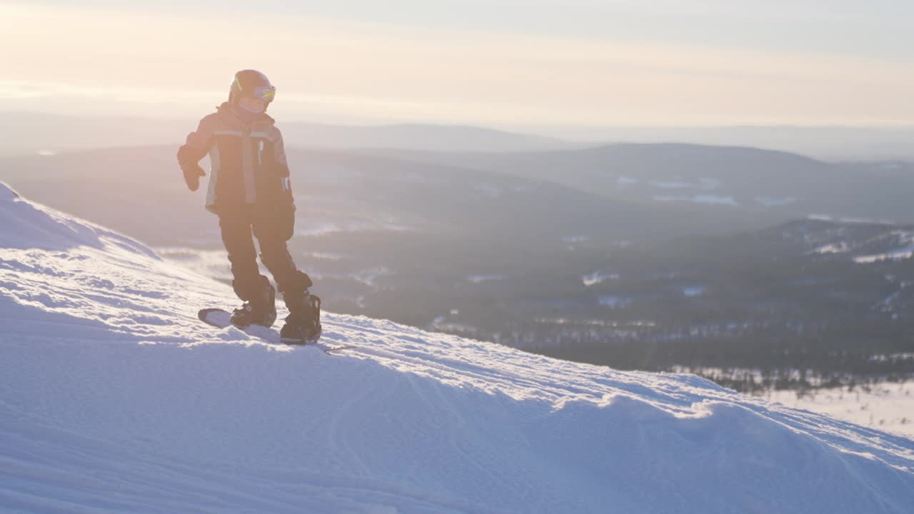 男孩在白天的雪景中单板滑雪视频下载