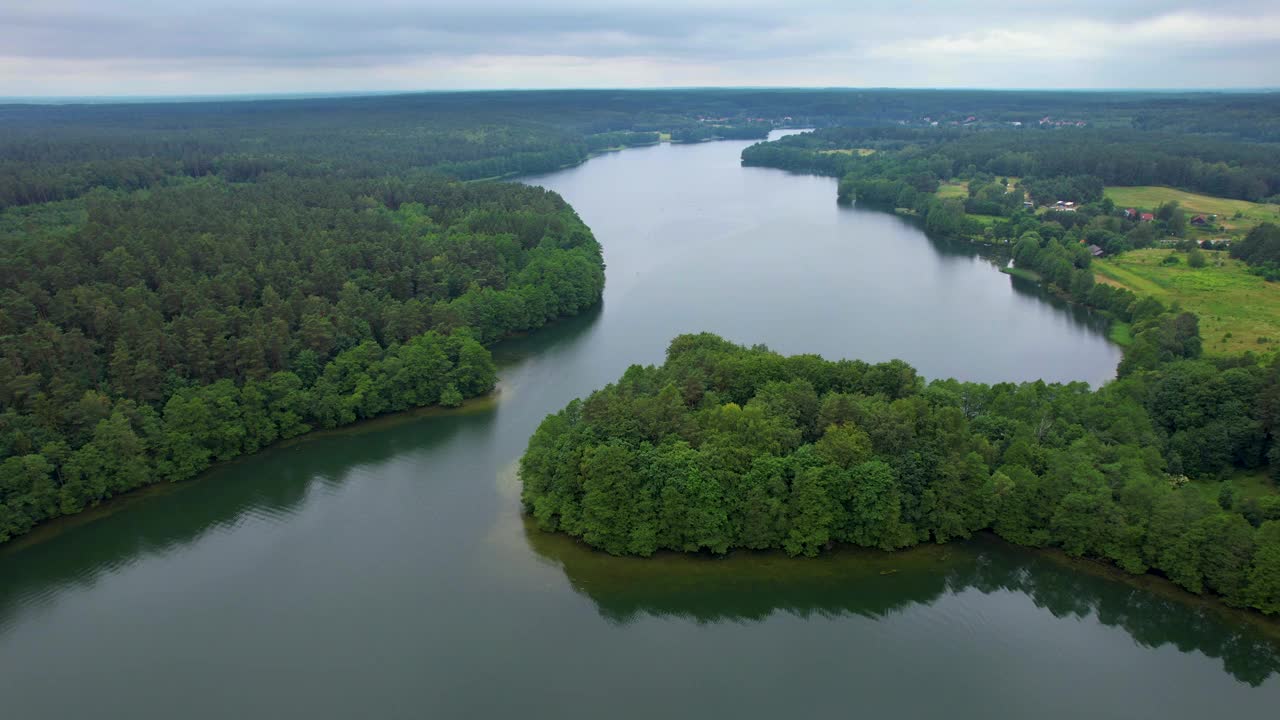 有河流穿过的森林地区。水是平静而清澈的。树木茂盛，天空多云。大湖和绿色森林的壮观鸟瞰图。壮丽自然景观自然保护区。视频下载