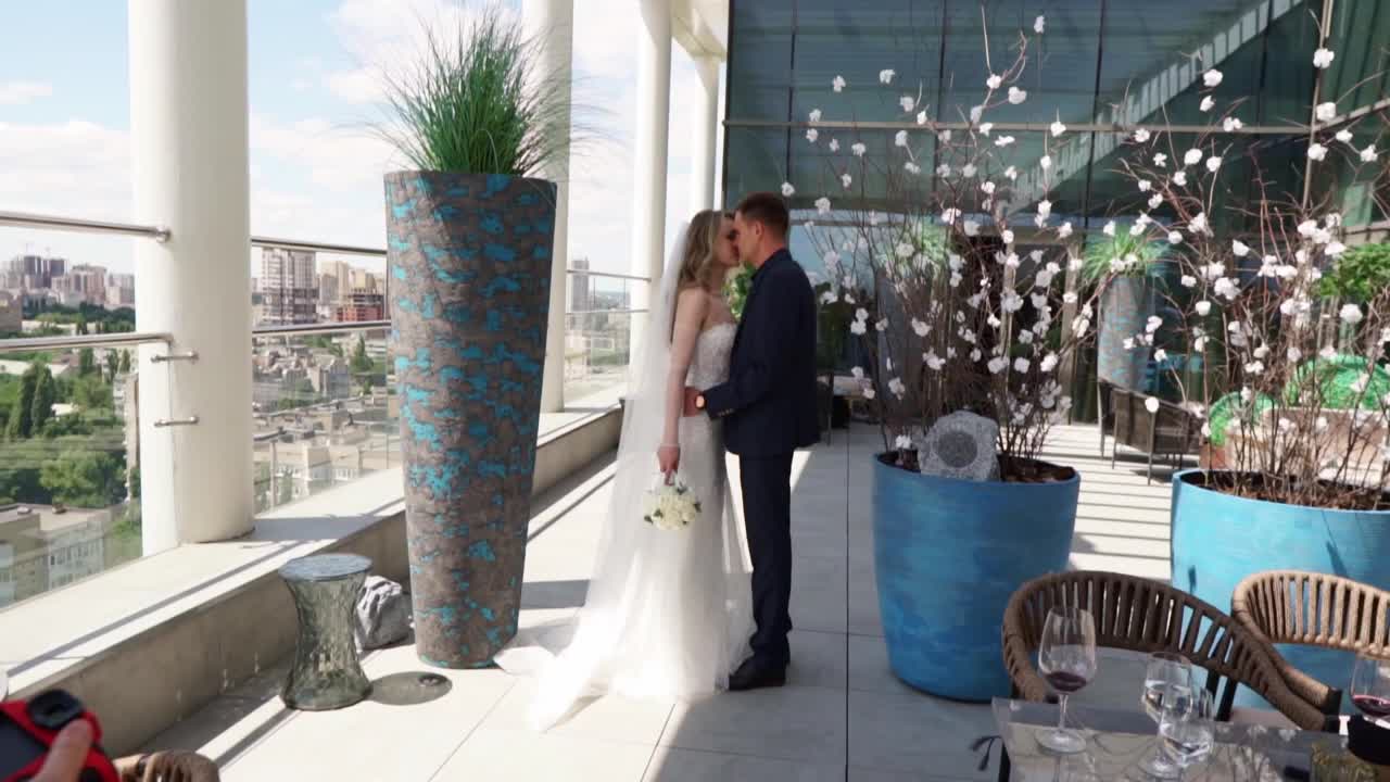 新娘和新郎在多层酒店露台上的后台照片视频素材
