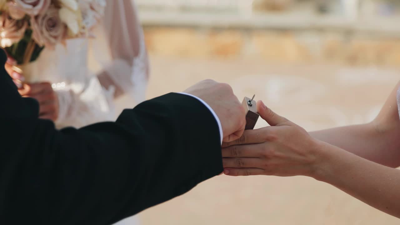 一个男人从首饰盒里拿出一枚结婚戒指。他的手是特写镜头视频下载