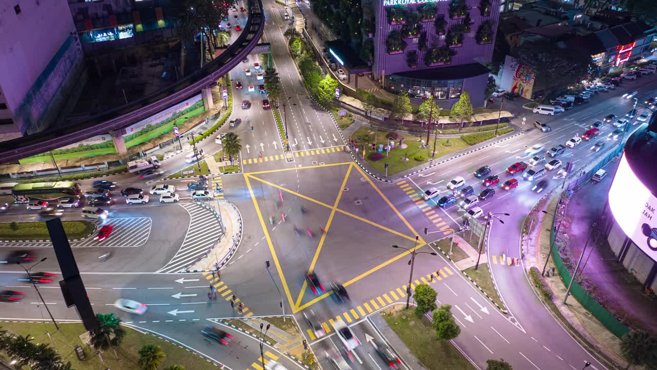 夜晚照亮吉隆坡市中心交通街道十字路口空中俯视全景4k延时马来西亚视频下载