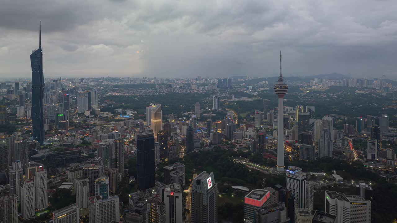 黄昏时分照明吉隆坡市中心著名的现代摩天大楼塔航拍全景4k延时马来西亚视频下载