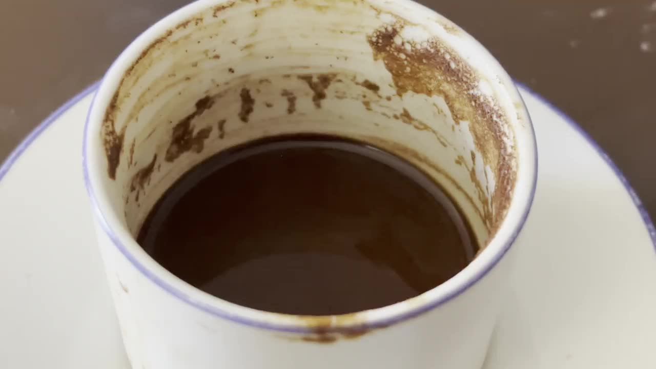 我猜是土耳其咖啡渣。咖啡杯与咖啡渣旋转。特写4k库存视频视频下载