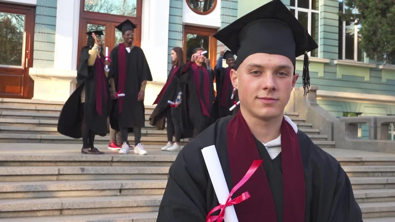毕业典礼后，一位男毕业生代表拿着他的毕业证书视频素材