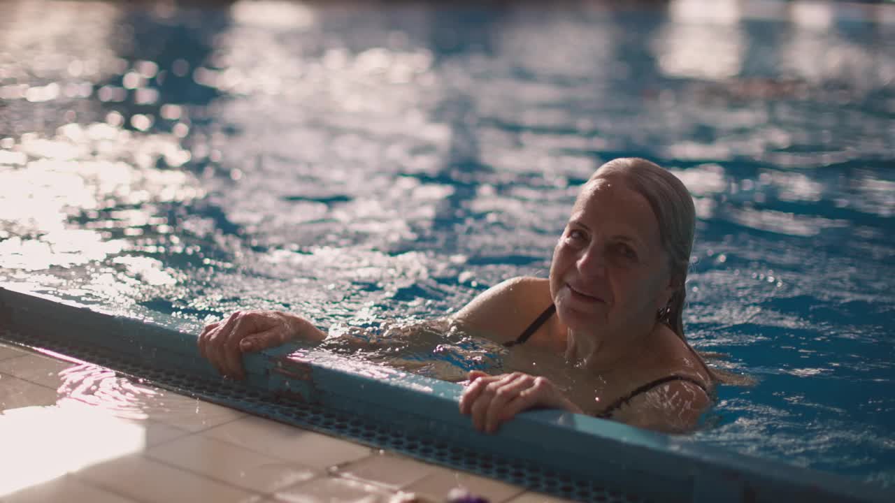 老年妇女在游泳池里享受视频下载