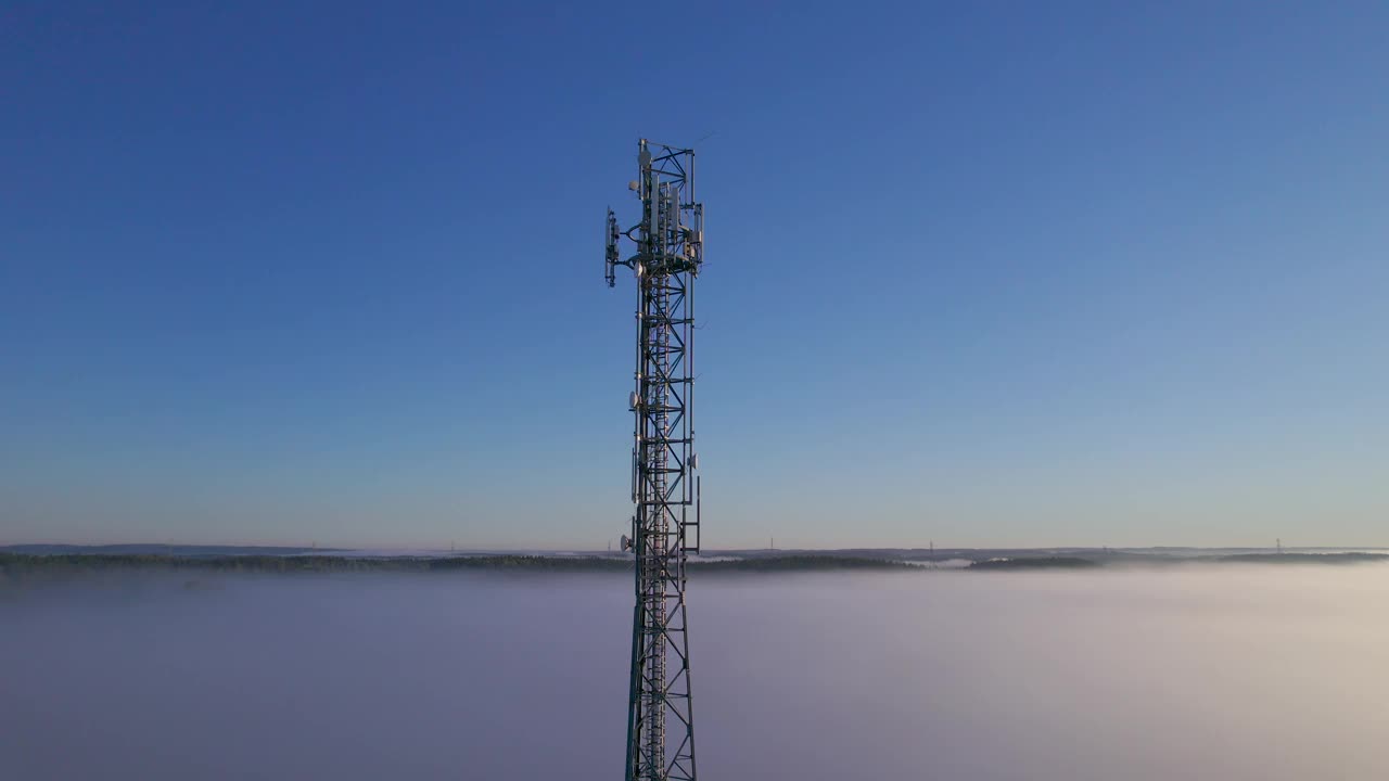 塔式天线电信手机鸟瞰图，蜂窝5g 4g手机无线电发射机。提供高速现代5g通信网服务。日出时的云雾和天空视频下载