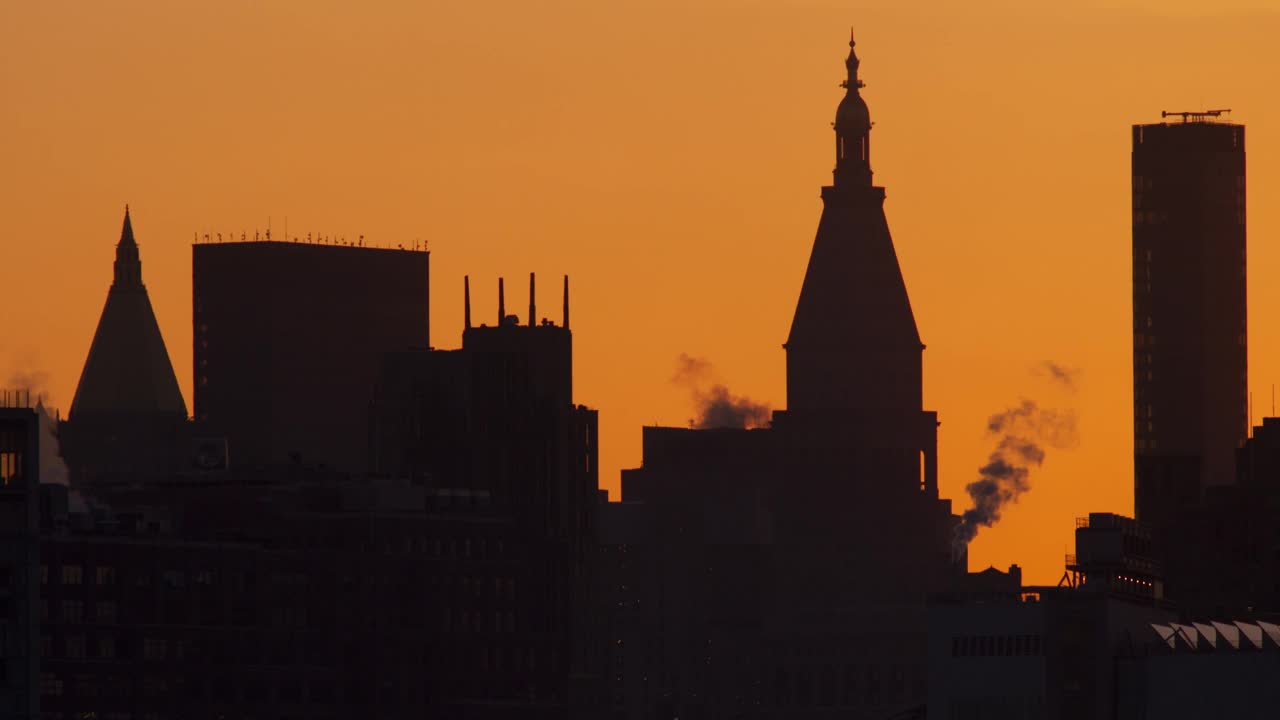 黎明时分，曼哈顿建筑的剪影映衬着橙色的天空视频下载
