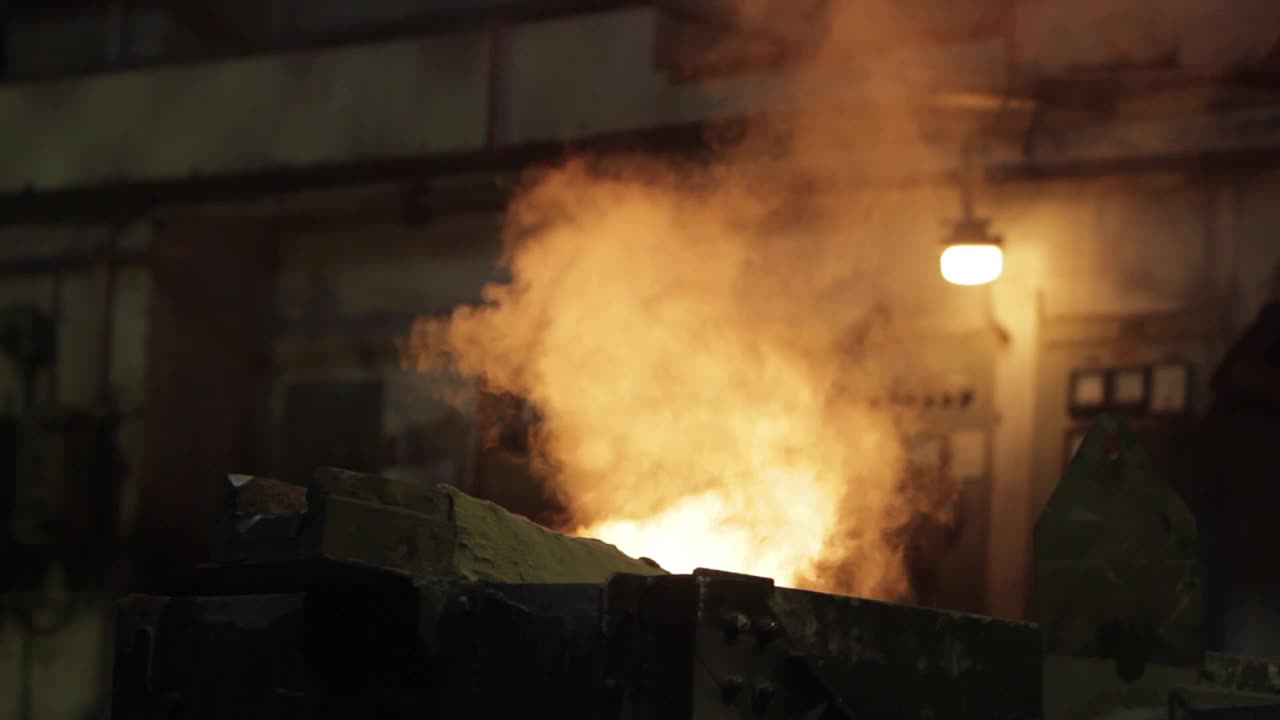 工业用钢的铸造工艺在铸造中有光亮的金属液浇注，强烈的热量，冒烟，铸造模具，环境工厂照明捕捉制造，冶金，工程。视频下载