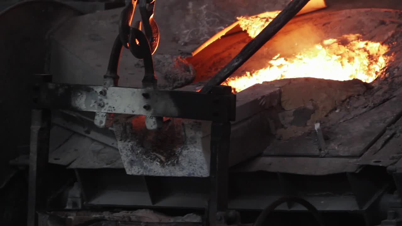 工业铸造铸钢，熔融金属从钢包倒进模具。重工业制造过程，极端高温，火花飞扬。工厂内的冶金、工程、设备操作。视频下载