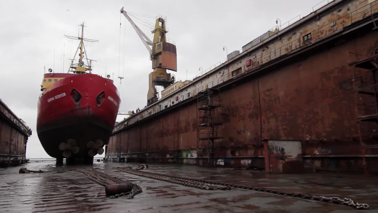 浮船坞修船与工人焊接，油漆船体，检查船舶结构为海事工业，造船过程中显示大型起重机，生锈的甲板，维修工作。视频下载